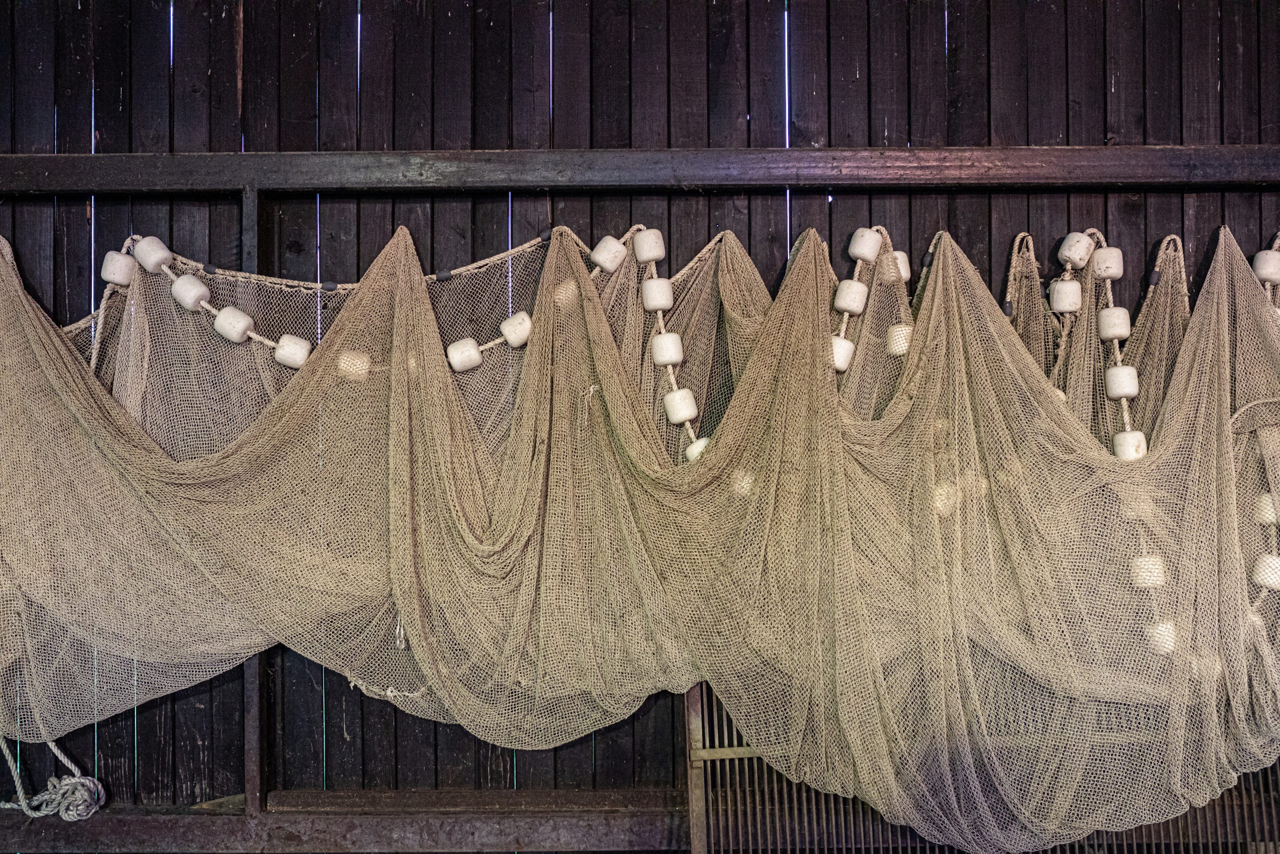 Mreže za ribolov visijo na leseni steni in se sušijo