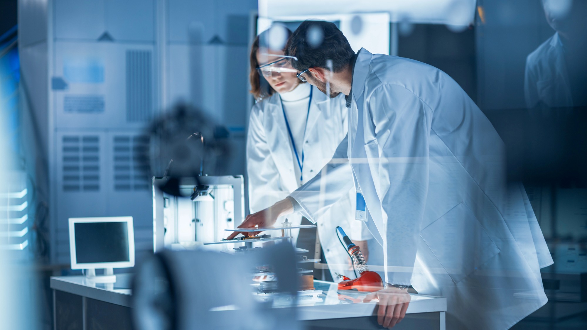 Znanstvenika v belih haljah pri delu v laboratoriju.