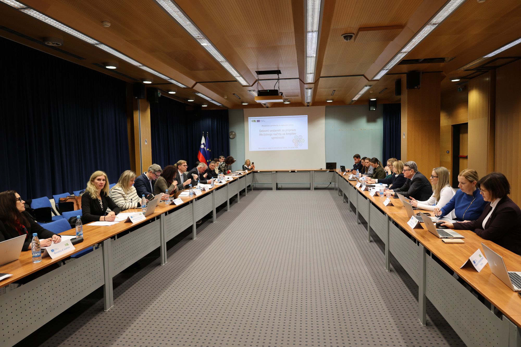 Delovno srečanje, ljudje sedijo za mizo v obliki črke U