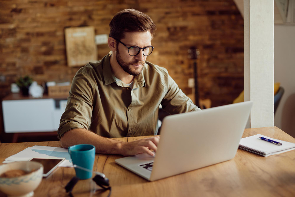 A man is sitting at a desk working on a computer.