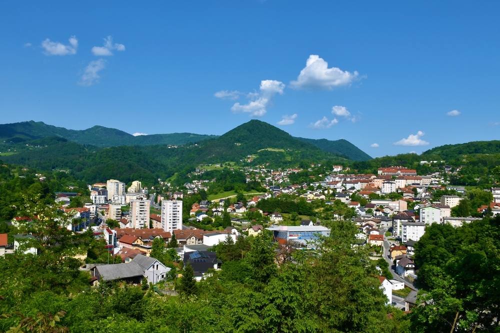 Oddaljen pogled na mesto Trbovlje z okoliškimi gozdovi.