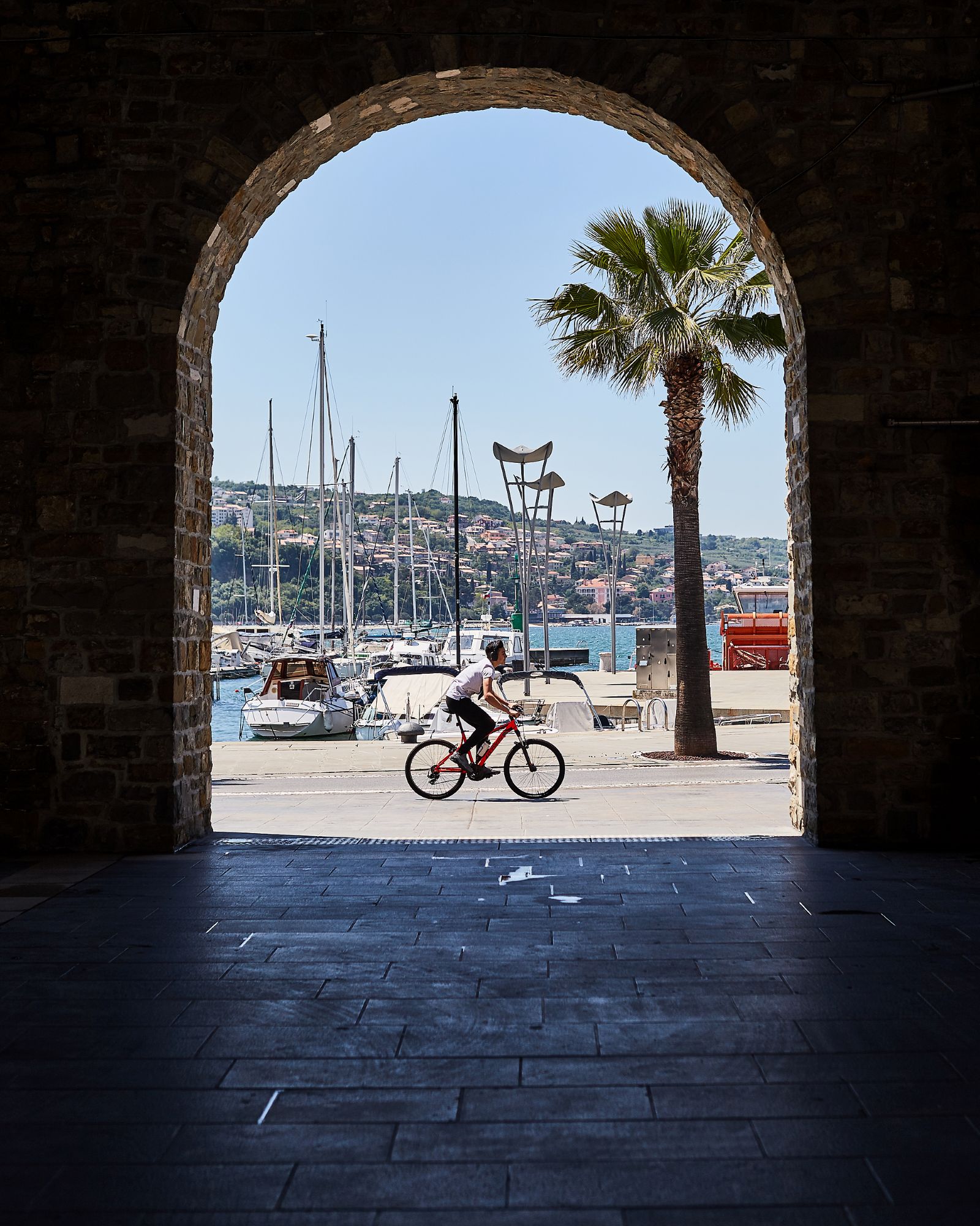 Moški kolesari po marini Koper